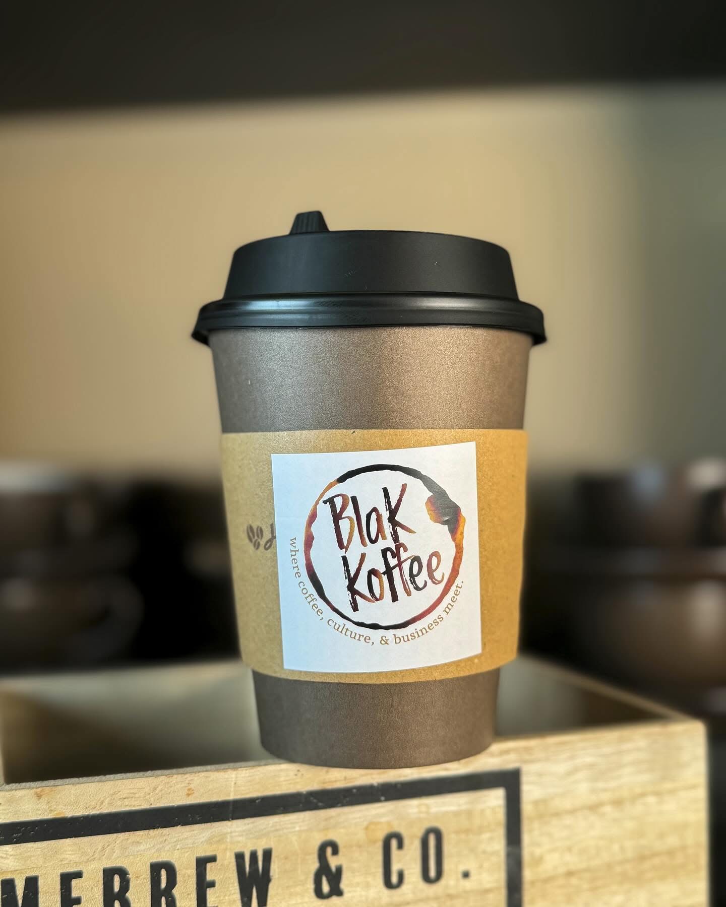 Blak Koffee branded to-go cup at a café counter