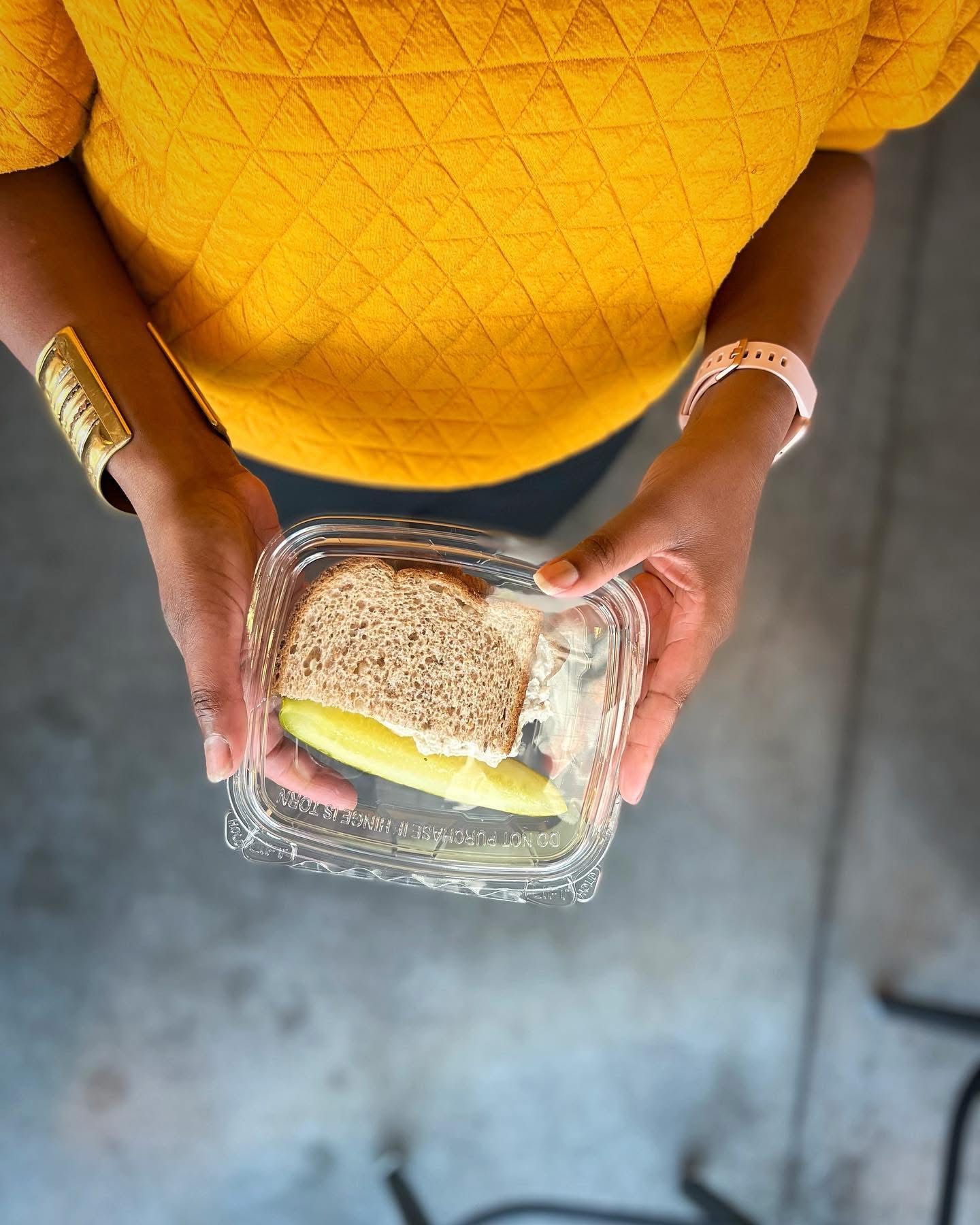 Sandwich in a to-go container held by Ronyale Smith